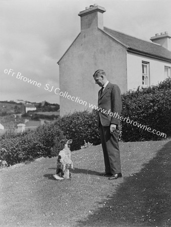 MAN WITH STANDING DOG